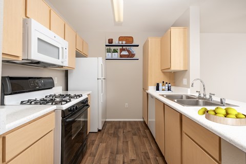 A kitchen with a white stove top oven and a white refrigerator.