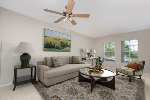 A living room with a couch, chair, and a painting on the wall.