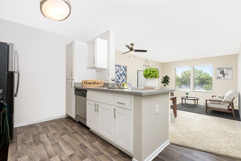 a renovated kitchen with white cabinets and a large counter top