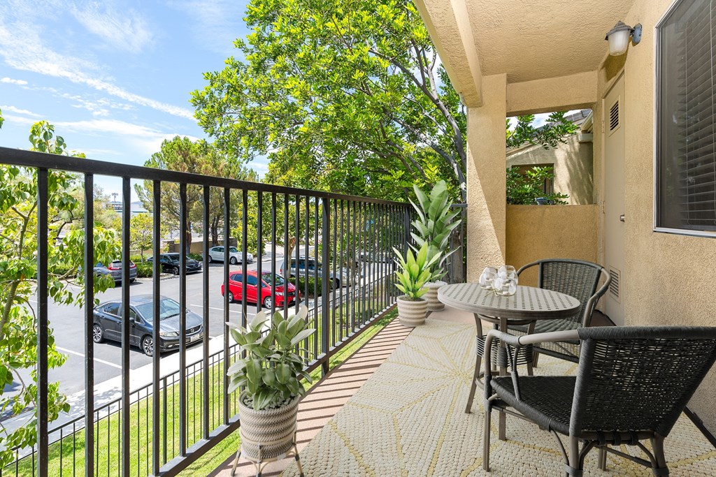 an apartment balcony with a table and chairs and a fence at 55+ FountainGlen Temecula, California, 92591