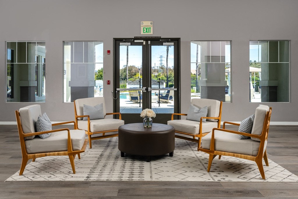 a lobby with chairs and a table in front of a door