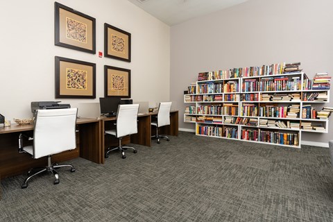 a library with desks and chairs and bookshelves at 55+ FountainGlen Valencia, California