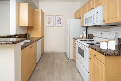 A kitchen with wooden cabinets and white appliances.