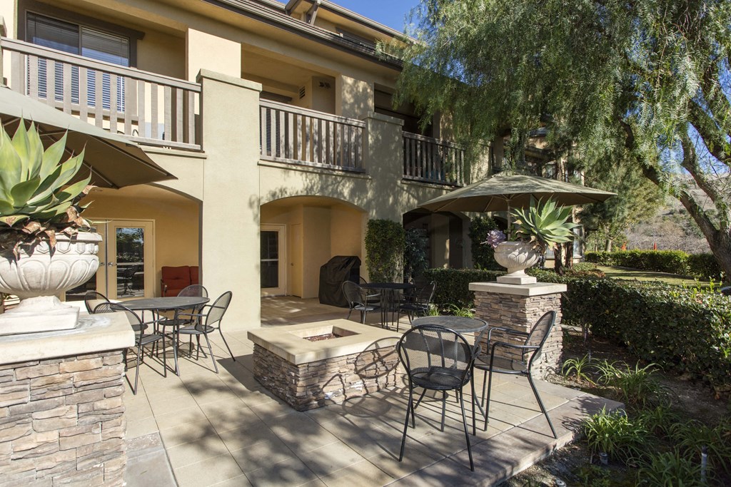 a patio with tables and chairs and a fire pit at 55+ Remington at Ladera Ranch, Ladera Ranch, CA