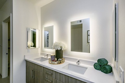 a bathroom with two sinks and three mirrors