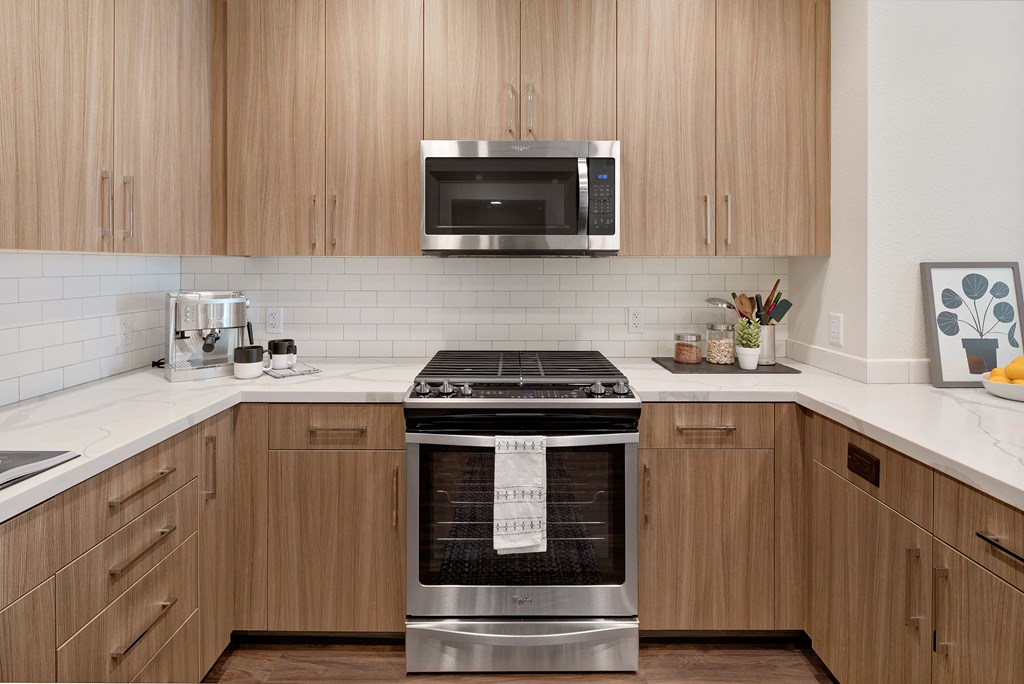 a kitchen with a stove and a microwave and wooden cabinets
