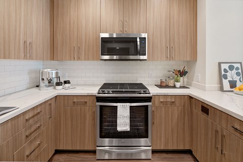 a kitchen with a stove and a microwave and wooden cabinets