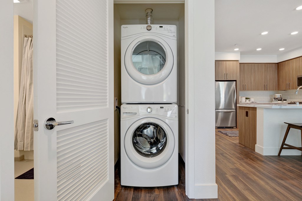 a white front loading washer and dryer in a room with a door