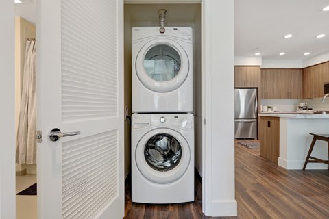 a white front loading washer and dryer in a room with a door