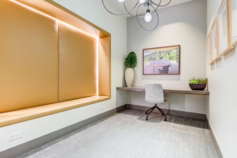 an office with a desk and a chair in a room with a large window