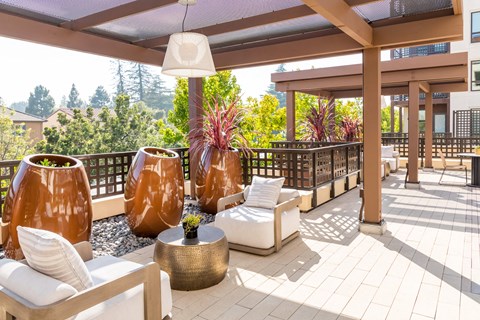 a patio with couches and tables and a roof