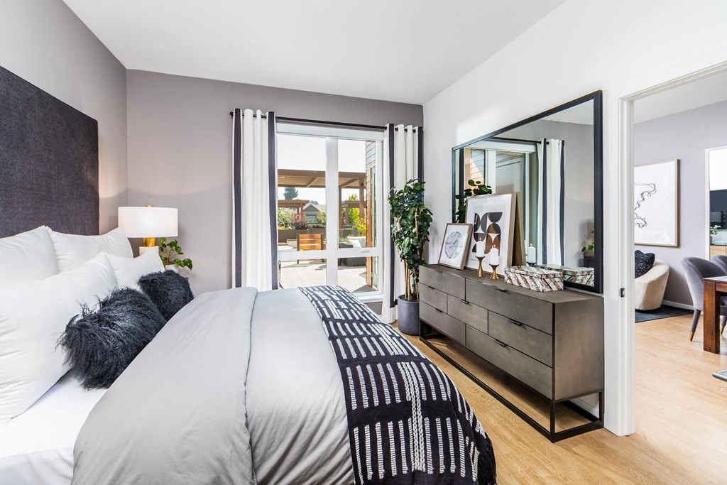 a bedroom with a large bed and a dresser with a mirror