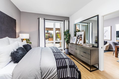 a bedroom with a large bed and a dresser with a mirror