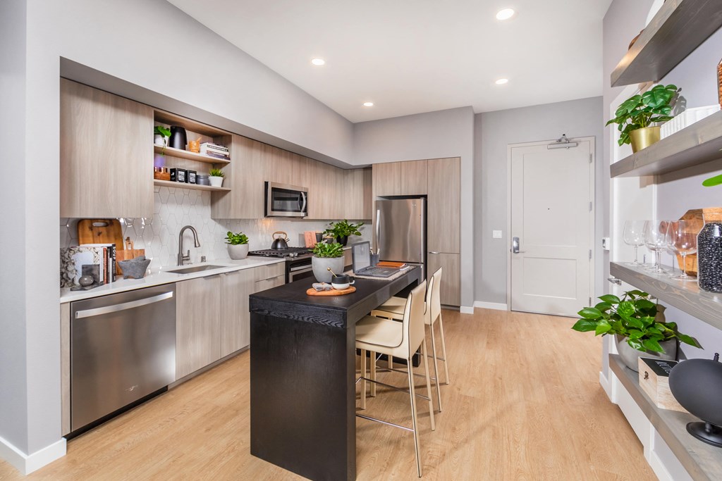 a kitchen and dining area with stainless steel appliances and a wood floor