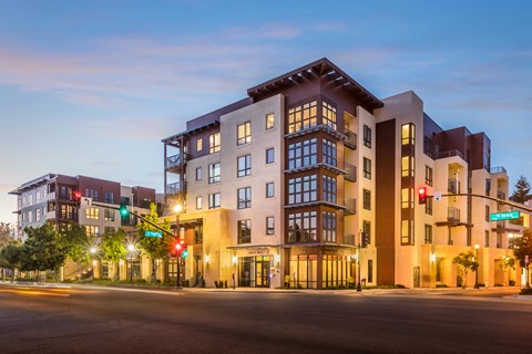 an apartment building at dusk on a city street