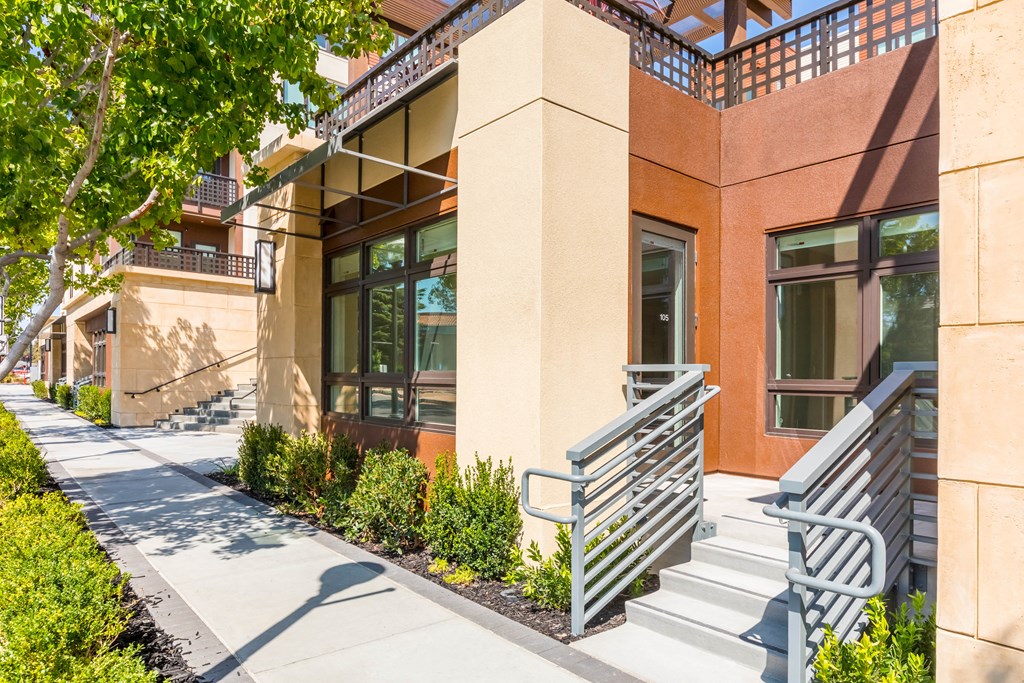 a building with a staircase and two benches outside of it