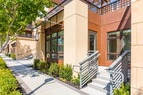 a building with a staircase and two benches outside of it