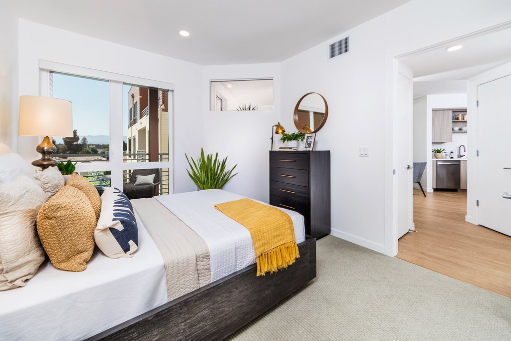 a bedroom with a bed and a dresser and a window