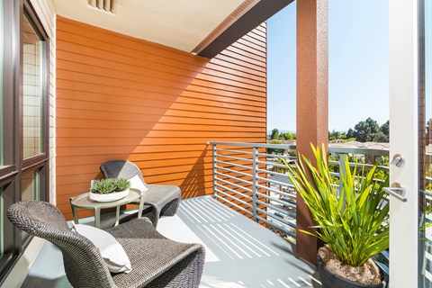 a balcony with two chairs and a table