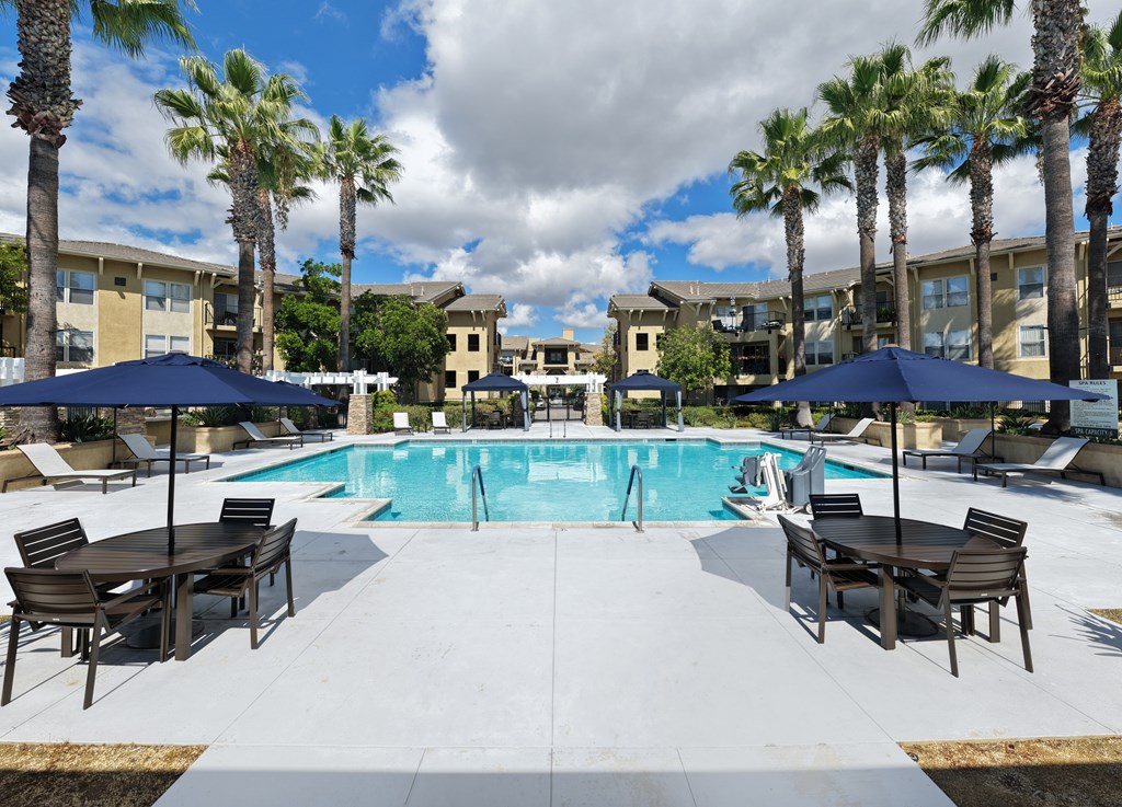 Pool area with tables and umbrellas at 55+ FountainGlen Temecula, Temecula, CA, 92591