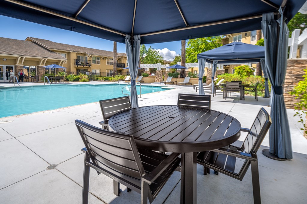 Pool area cabanas with tables and chairs at 55+ FountainGlen Temecula, Temecula, California