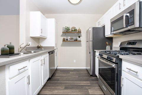 A kitchen with white cabinets and black appliances.