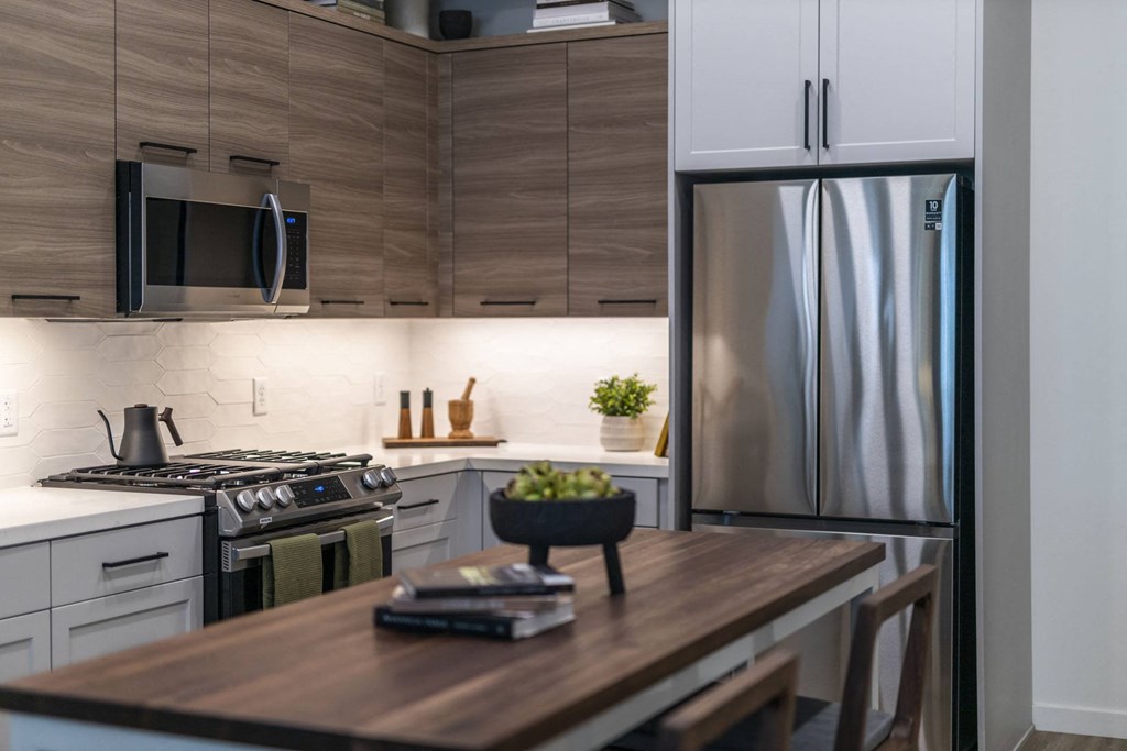 a kitchen with stainless steel appliances and a wooden table