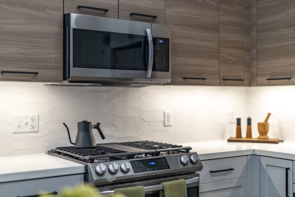 a kitchen with a stove and a microwave above it