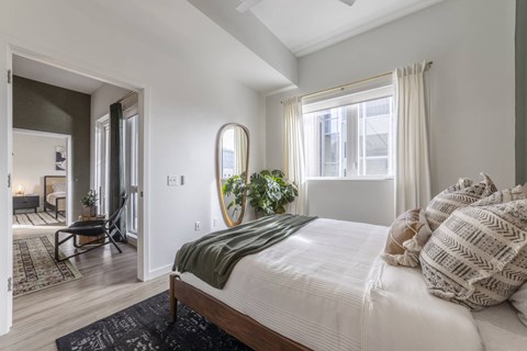 a bedroom with a bed and a large window