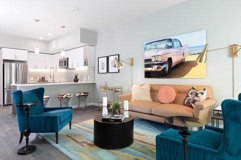 a living room with a couch and chairs and a kitchen