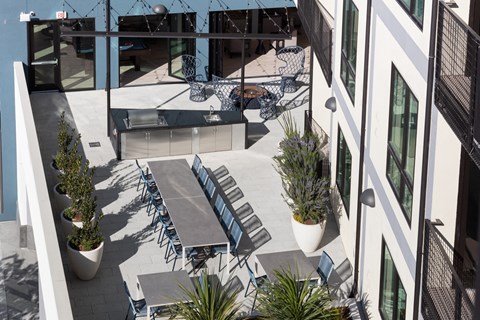 a communal patio with tables and chairs and potted plants