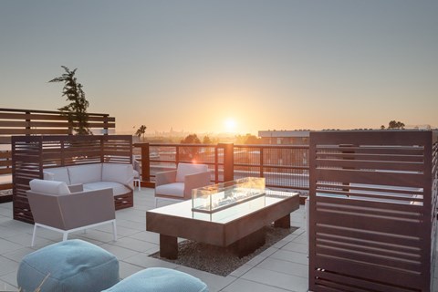 a terrace with a table and chairs and a sunset