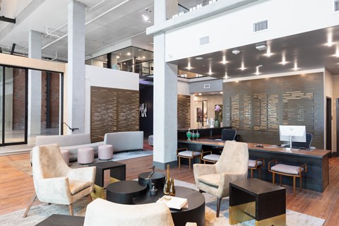 a large lobby with chairs and tables and a reception desk