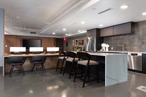 a kitchen with a bar and chairs in front of a counter top