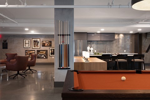 a living room with a pool table and a bar