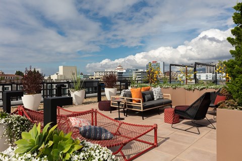 a roof top patio with furniture and a city in the background