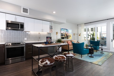 a kitchen and living room with a table and stools