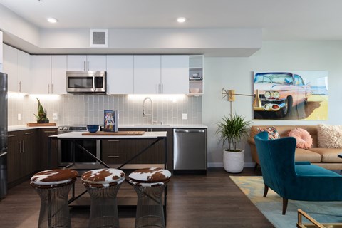 a kitchen and living room with a table and stools