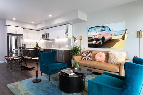 a living room and kitchen with a couch and chairs