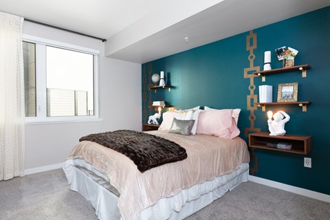 a bedroom with a bed and a green wall and a window