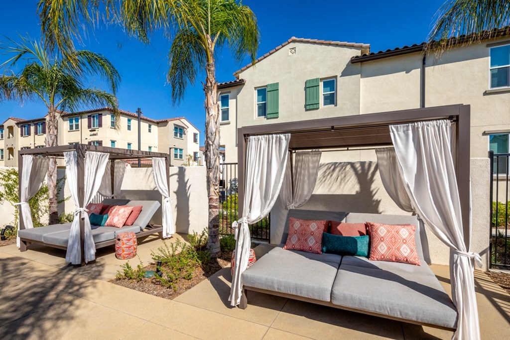 a patio with two cabanas and palm trees