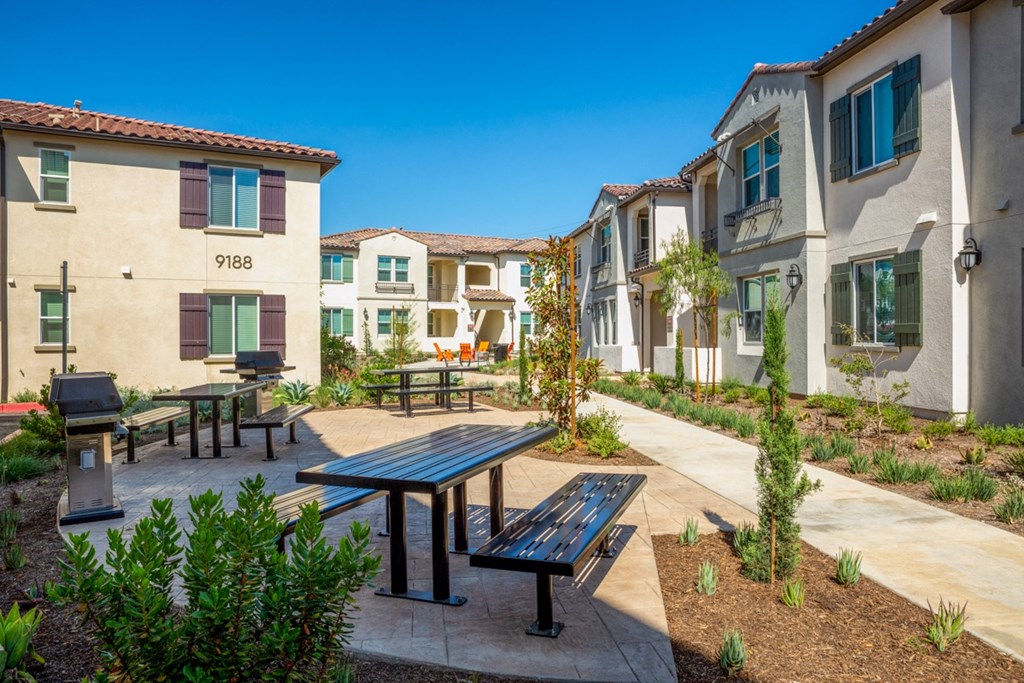 a group of apartments with picnic tables and benches