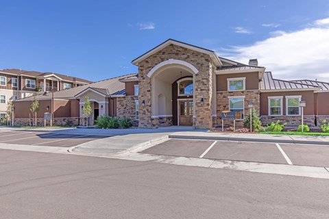A building with a stone archway entrance and a parking lot in front.
