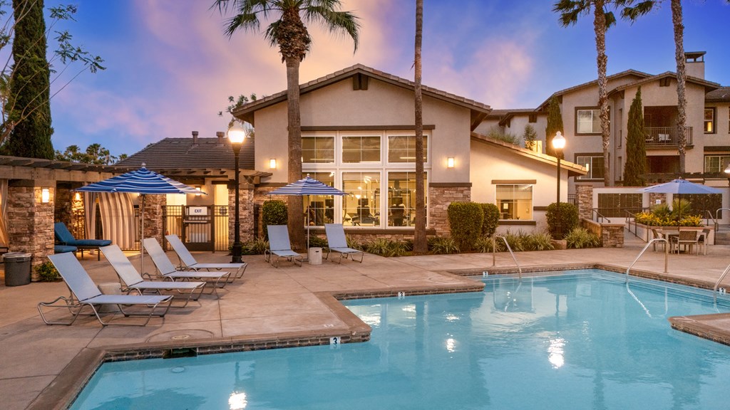 Pool surrounded by lounge chairs at The Grove Apartments, Ontario, CA, 91761