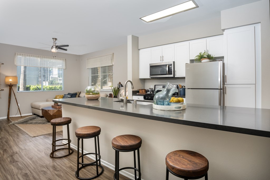 Kitchen with a bar area and a refrigerator at The Grove Apartments, Ontario, CA
