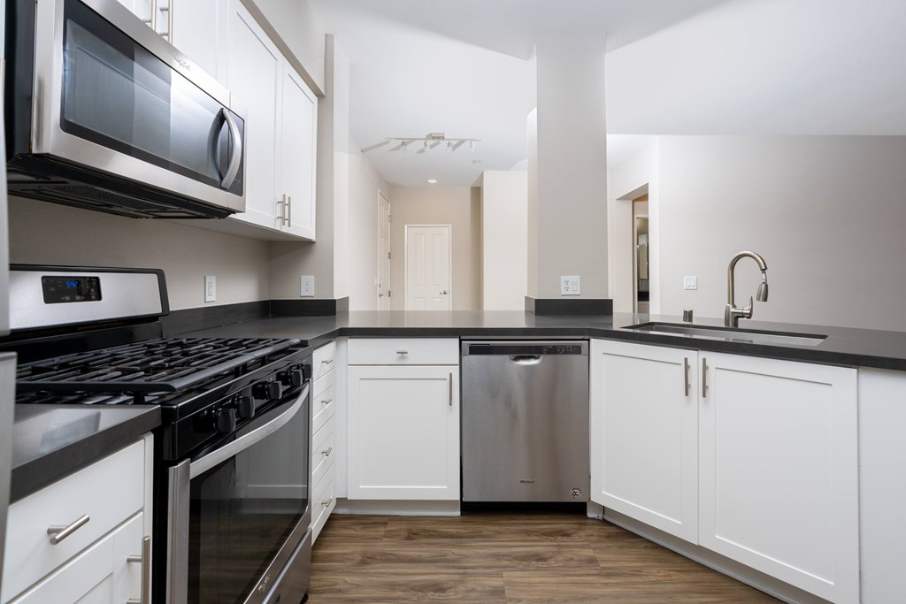 Modern kitchen with white cabinets at The Grove Apartments, Ontario
