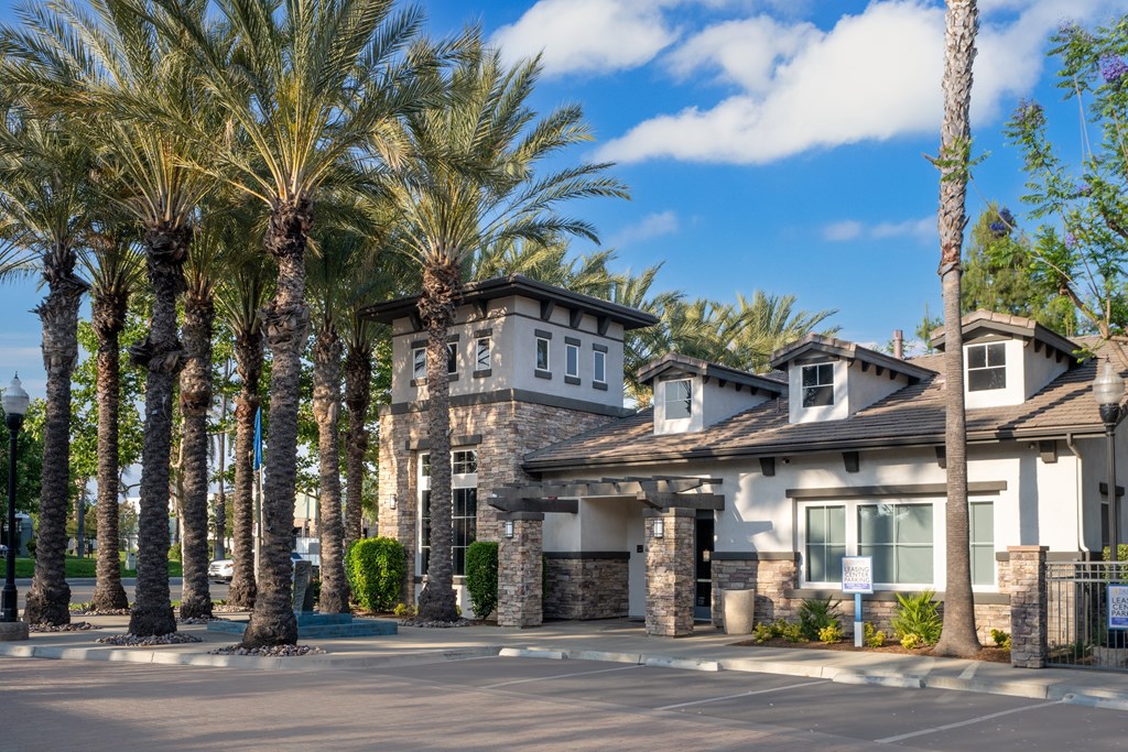Row of palm trees line the front of a building at The Grove Apartments, Ontario, CA