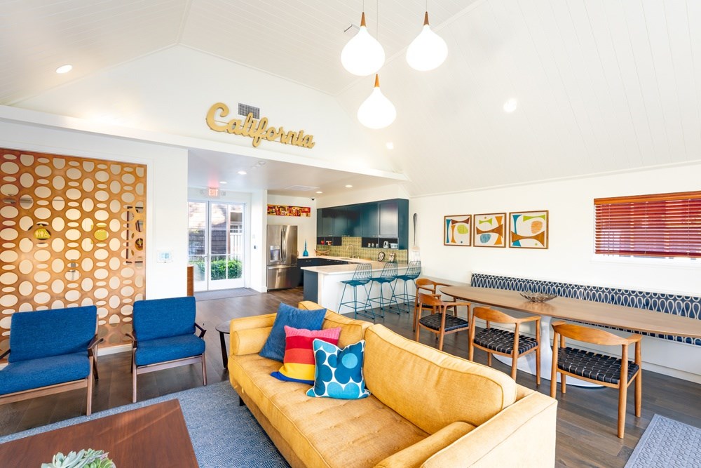 A living room with a yellow couch and a sign that says California.