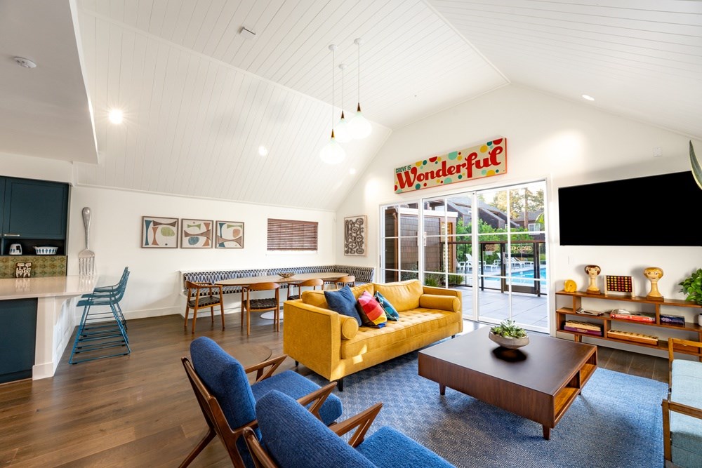 A living room with a yellow couch and a sign that says "Wonderful".