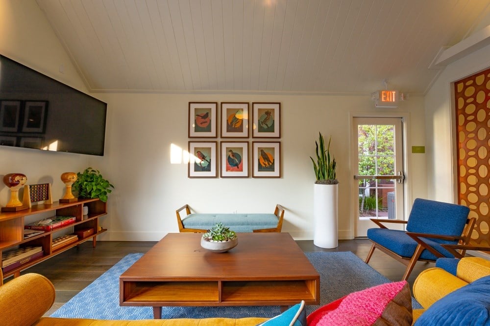 A living room with a blue rug and a wooden coffee table.